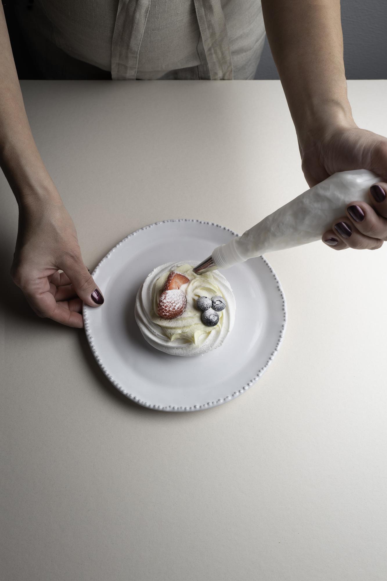 Close-up of hands plating fine dining dish